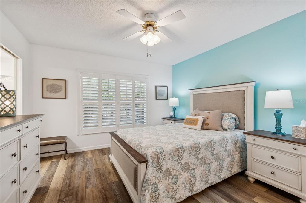 2291 Americus Boulevard West, Unit 3 Clearwater, FL 33763 - Photo 24 of 88 a bedroom with a large bed and a chandelier fan