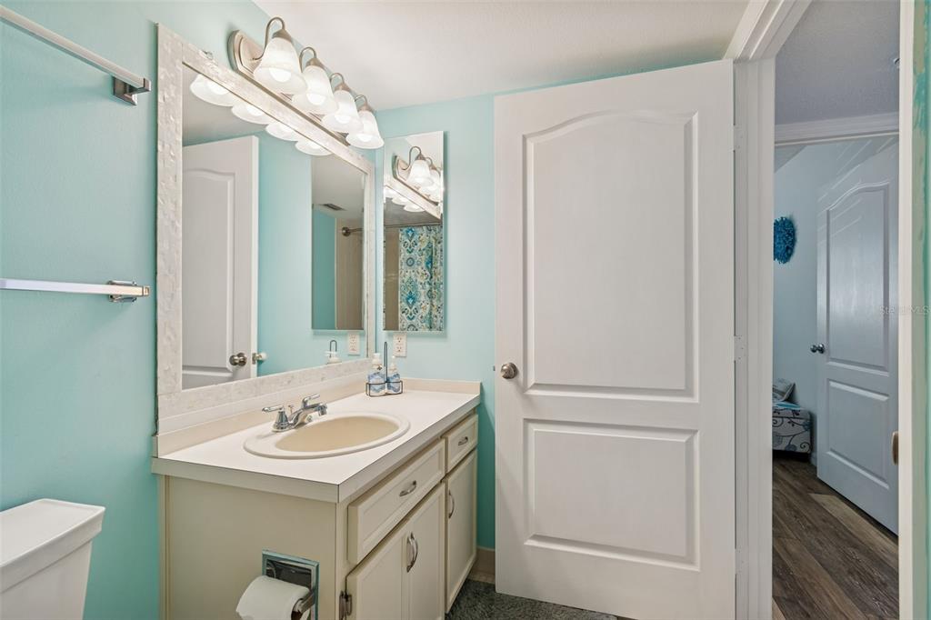 2291 Americus Boulevard West, Unit 3 Clearwater, FL 33763 - Photo 39 of 88 a bathroom with a sink a mirror and a shower