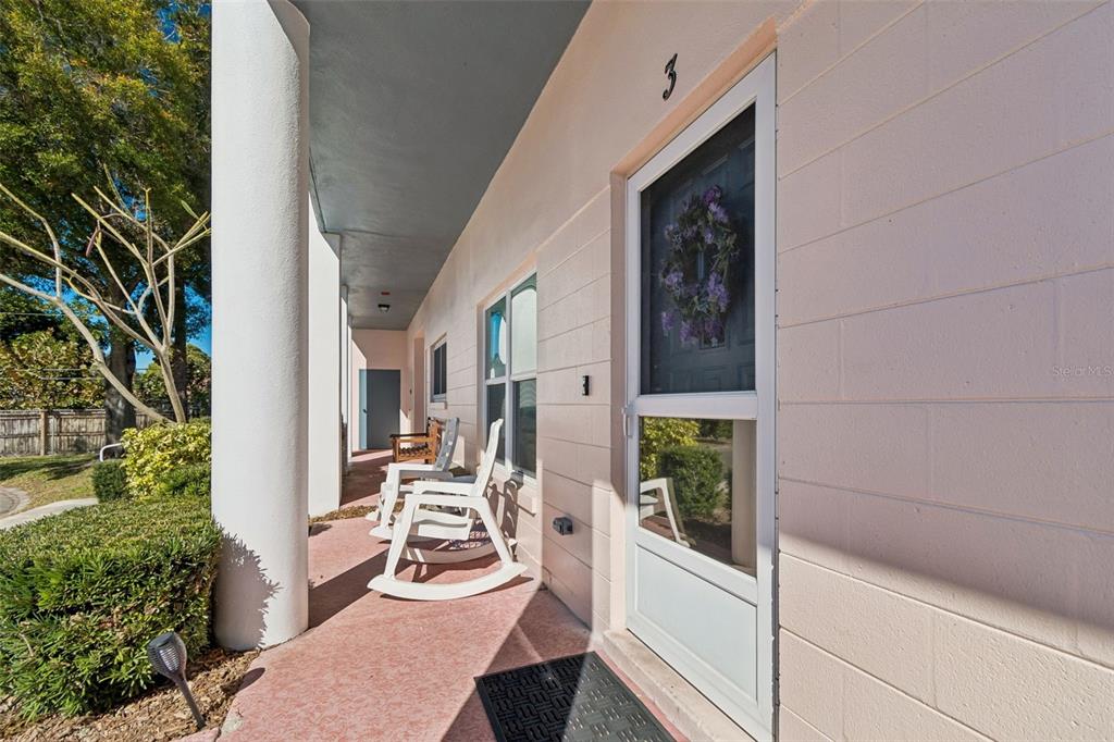 2291 Americus Boulevard West, Unit 3 Clearwater, FL 33763 - Photo 57 of 88 a view of a balcony with chairs and floor to ceiling window and potted plants
