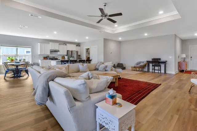 a kitchen with stainless steel appliances a dining table chairs refrigerator and sink