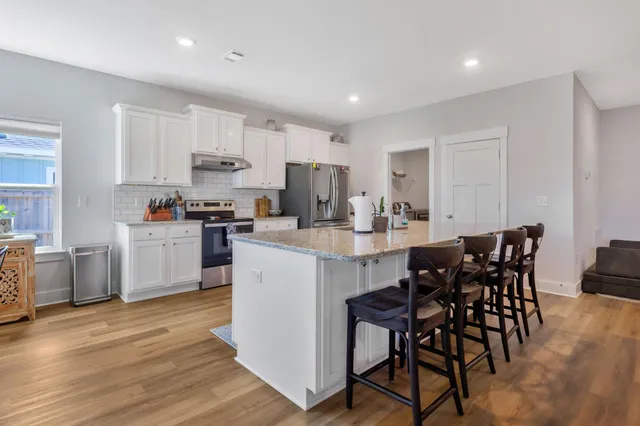 a kitchen with sink refrigerator and wooden floor