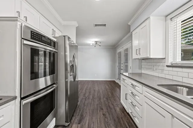 a kitchen with stainless steel appliances a stove microwave and sink