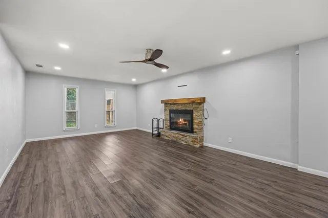a view of empty room with wooden floor and fireplace