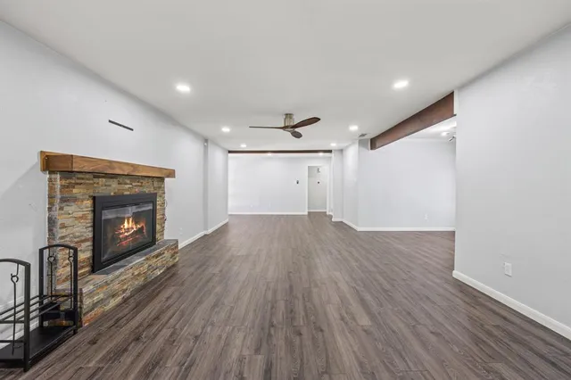 a view of empty room with wooden floor and fireplace