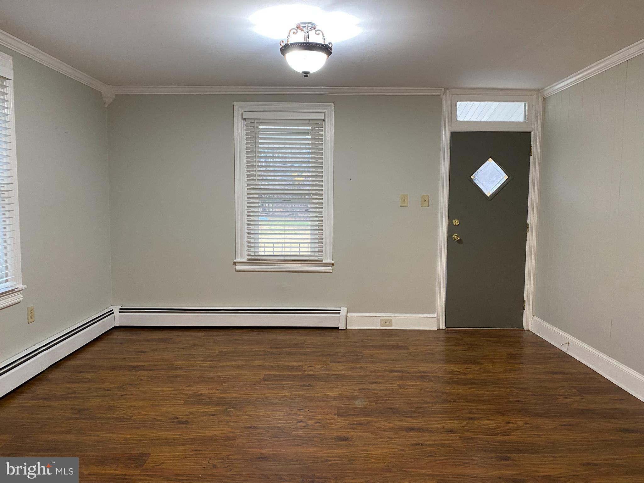 629 Convent Road Aston, PA 19014 - Photo 4 of 18 an empty room with wooden floor and windows