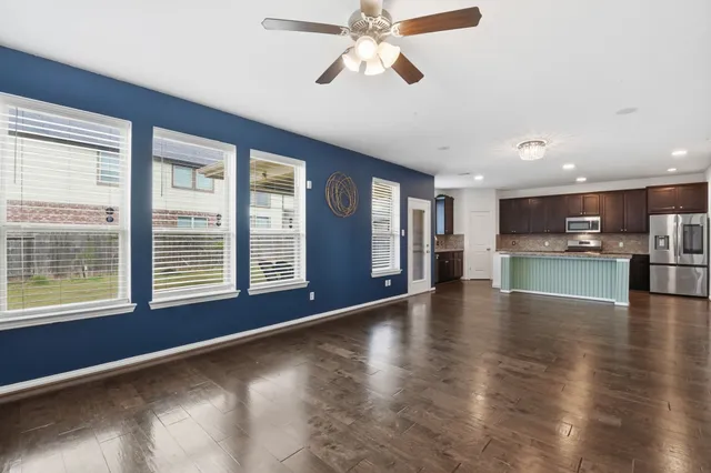 a view of an empty room with a window and wooden floor