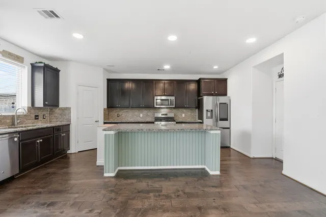 a kitchen with stainless steel appliances granite countertop a sink and a stove