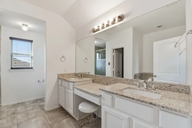 a bathroom with a granite countertop sink a mirror and a vanity