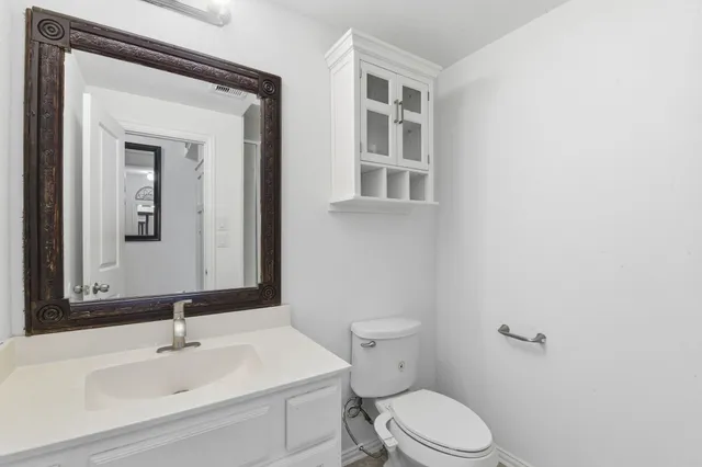a bathroom with a sink mirror and toilet