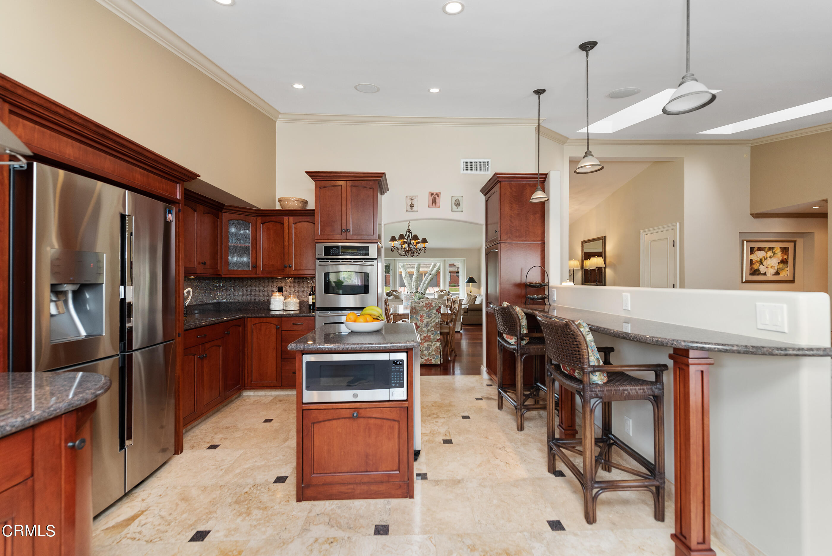 6893 Aviano Drive Camarillo, CA 93012 - Photo 18 of 67 a kitchen with stainless steel appliances kitchen island granite countertop a table chairs and a refrigerator