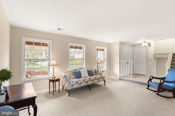 a view of a dining room and livingroom with furniture wooden floor a chandelier