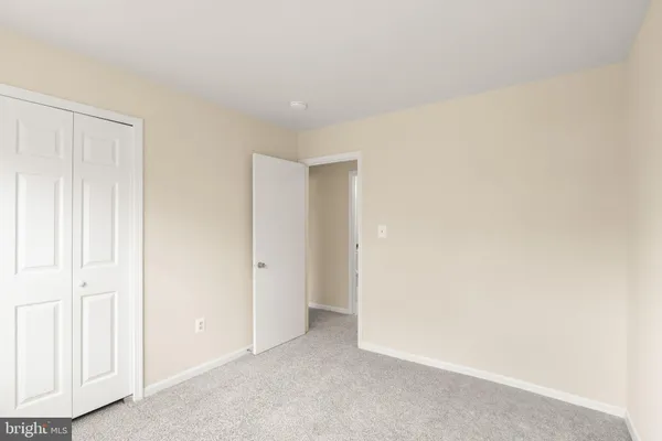 a view of a white building with a large tree and wooden fence