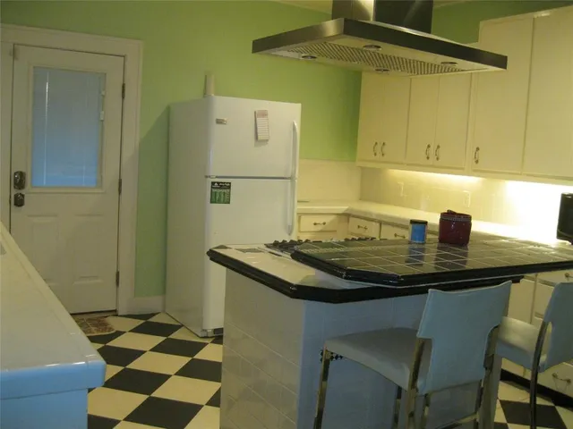 a kitchen with a sink a refrigerator and cabinets