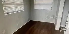 a view of a hallway with wooden floor and a window