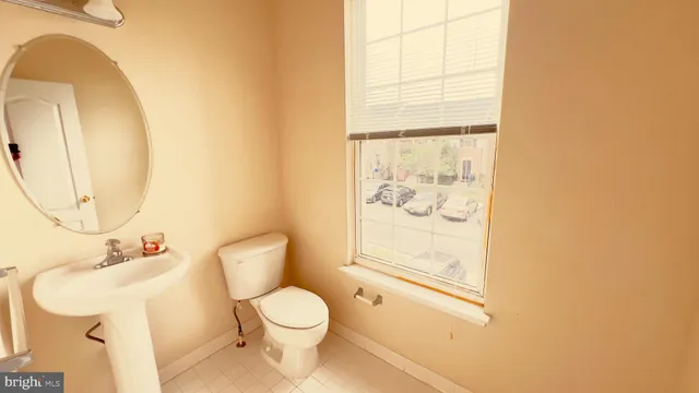 a white toilet sitting next to a bathroom sink and a mirror