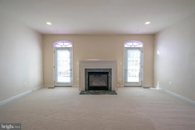 an empty room with a fireplace and window