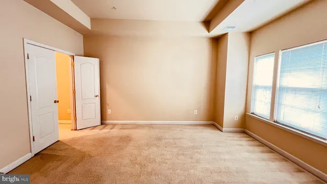 an empty room with windows and closet