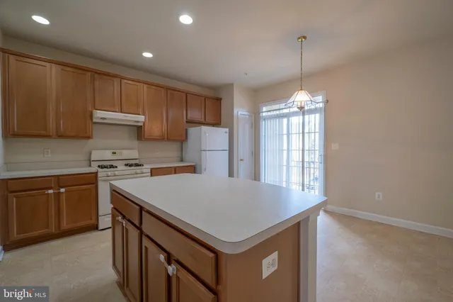 a kitchen with a stove a sink a center island and cabinets