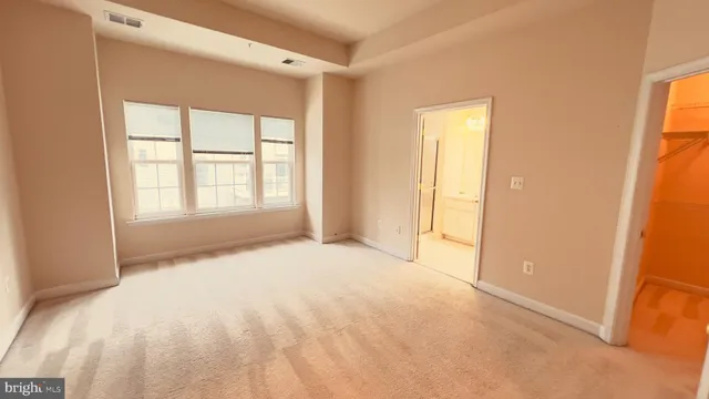 an empty room with windows and closet