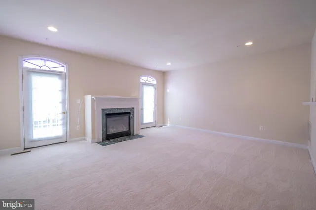 an empty room with a fireplace and window
