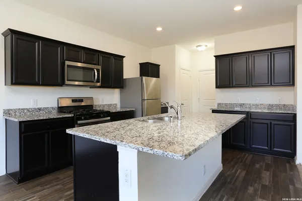 a kitchen with stainless steel appliances granite countertop wooden cabinets a stove top oven a sink and dishwasher
