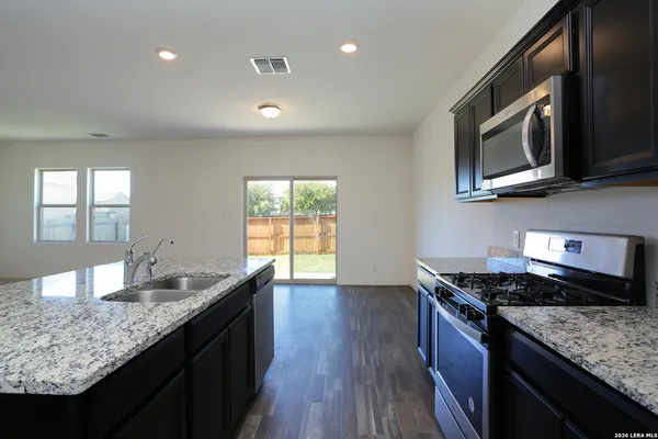 a kitchen with stainless steel appliances granite countertop a sink stove and microwave