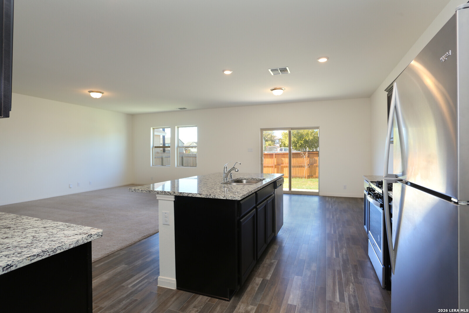 4913 Hallies Garden St. Hedwig, TX 78152 - Photo 9 of 23 a kitchen with stainless steel appliances granite countertop a refrigerator a sink dishwasher a stove and white countertops with wooden floor