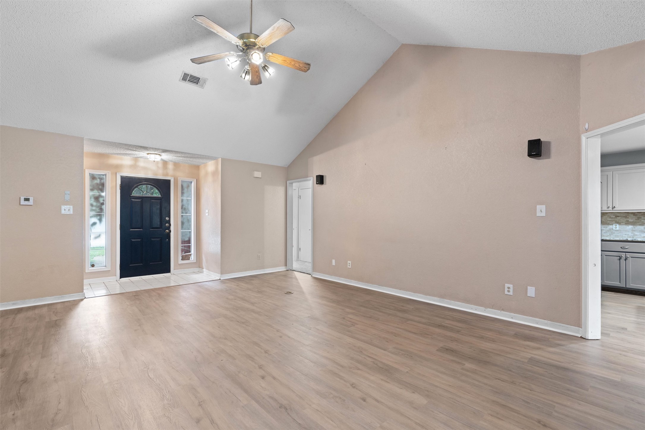 2306 Raintree Path Round Rock, TX 78664 - Photo 3 of 23 A spacious living area welcomes with vaulted ceilings and durable wood flooring.