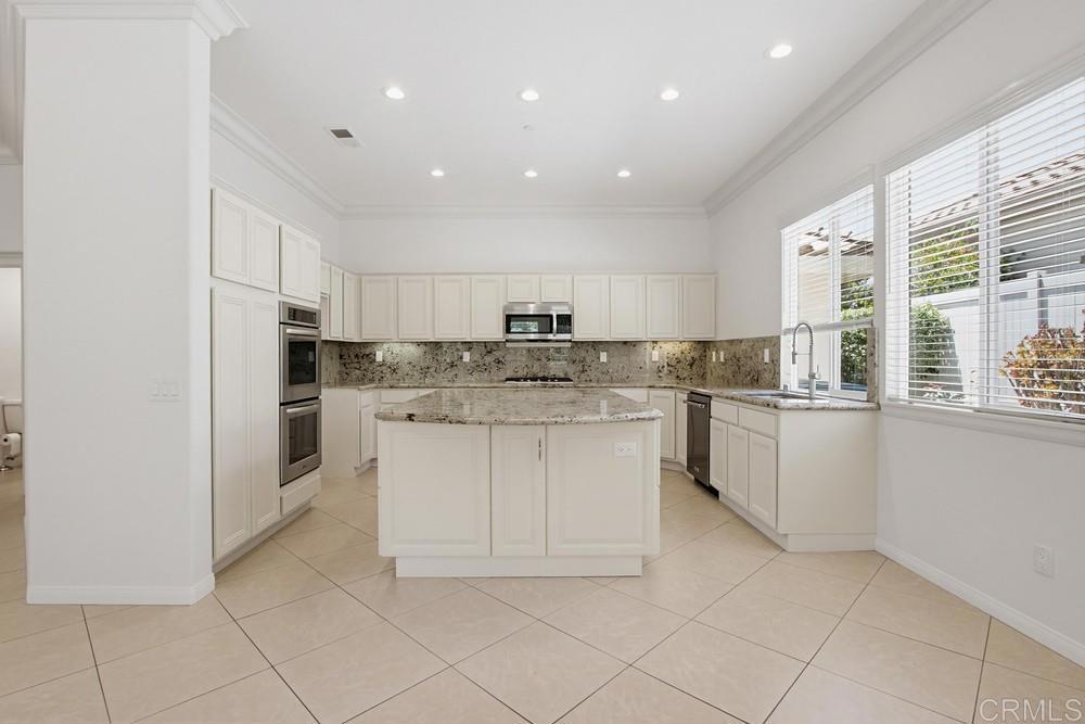 672 Inverlochy Drive Fallbrook, CA 92028 - Photo 16 of 75 a kitchen with white cabinets stainless steel appliances and a window