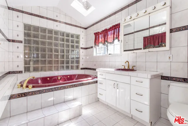 a bath room with a sink cabinets and a bath tub