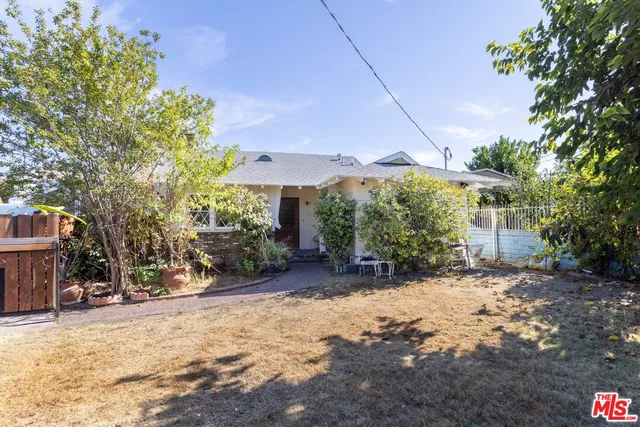 a view of a house with a yard and tree