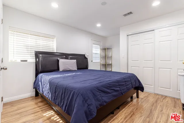 a bedroom with a bed and wooden floor