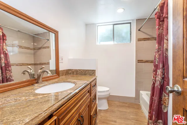 a bathroom with a granite countertop sink toilet and shower