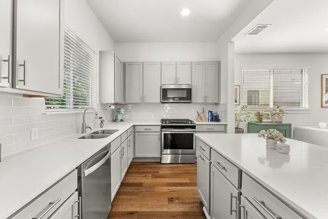 a kitchen with stainless steel appliances granite countertop a sink stove microwave and cabinets