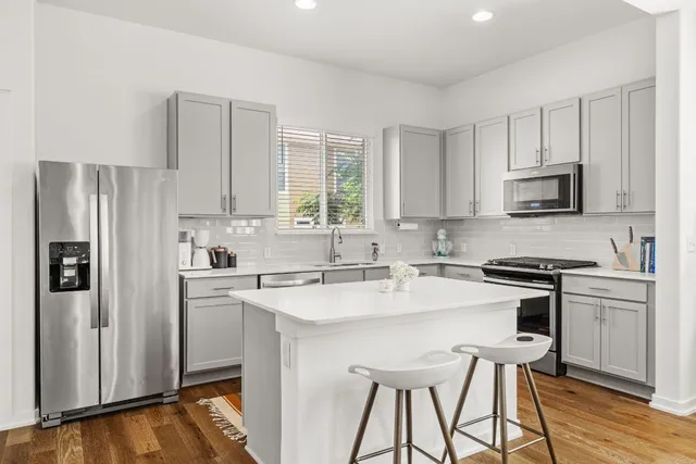 a kitchen with stainless steel appliances a stove a sink refrigerator and a microwave