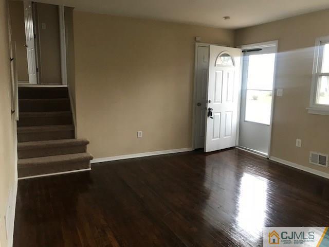 218 McFarlane Road Colonia, NJ 07067 - Photo 4 of 18 a view of an empty room with wooden floor and a window