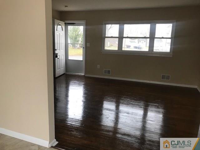 218 McFarlane Road Colonia, NJ 07067 - Photo 5 of 18 an empty room with wooden floor and windows