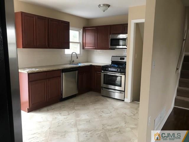 218 McFarlane Road Colonia, NJ 07067 - Photo 8 of 18 a kitchen with stainless steel appliances granite countertop a stove and a sink