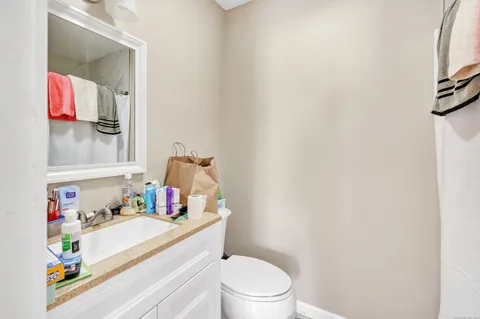 a bathroom with a granite countertop toilet sink and mirror