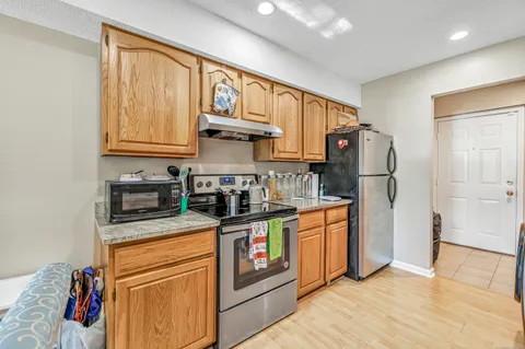 a kitchen with stainless steel appliances granite countertop a refrigerator a stove and a sink