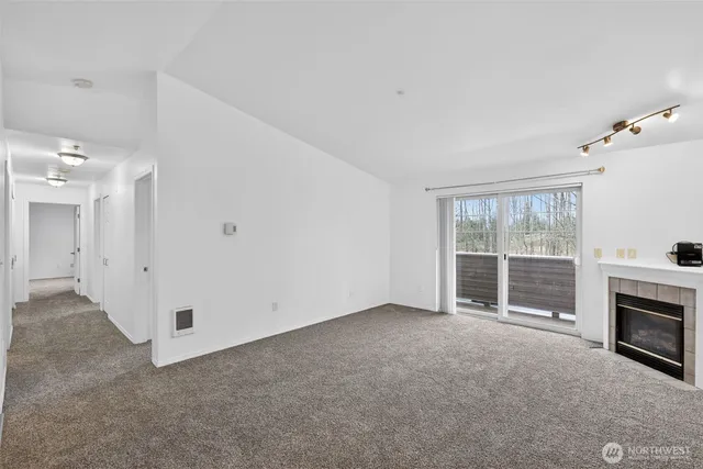 a view of an empty room with window and stairs