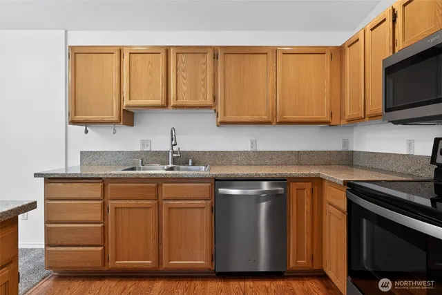 a kitchen with stainless steel appliances granite countertop a sink stove and microwave