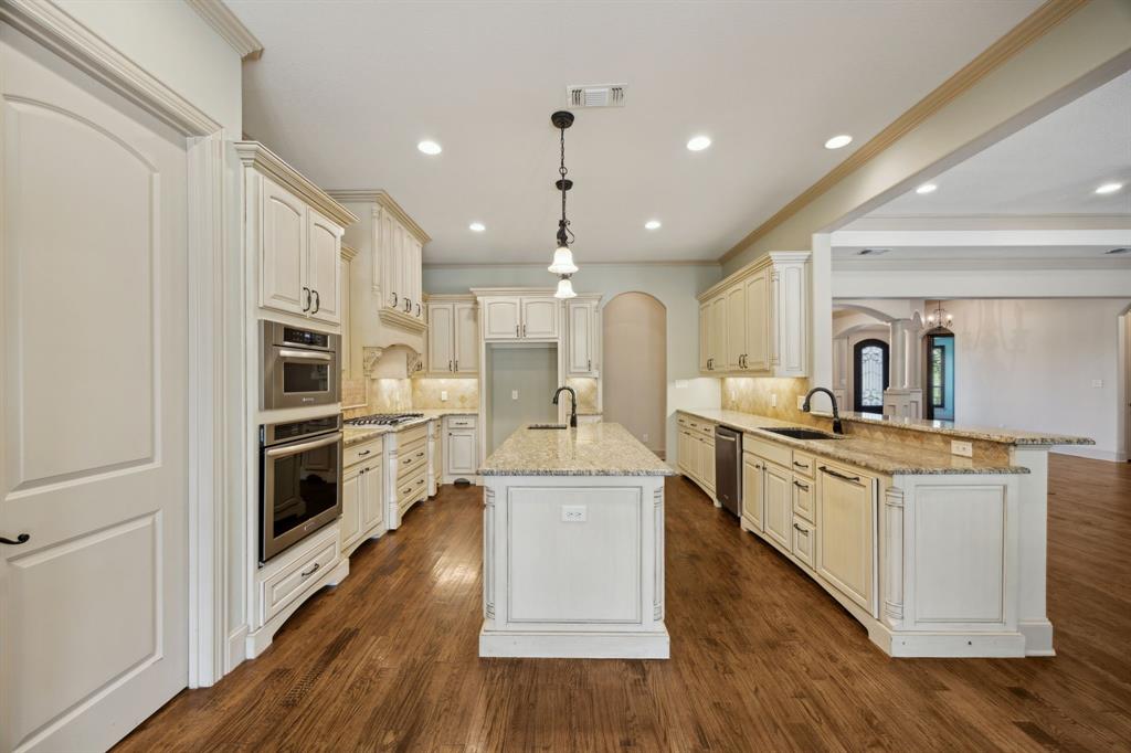 301 Harrison Circle Van Alstyne, TX 75495 - Photo 15 of 38 a kitchen with stainless steel appliances kitchen island granite countertop a stove a sink a refrigerator and white cabinets with wooden floor