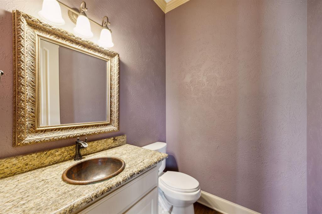 301 Harrison Circle Van Alstyne, TX 75495 - Photo 26 of 38 a bathroom with a granite countertop sink a toilet and a mirror