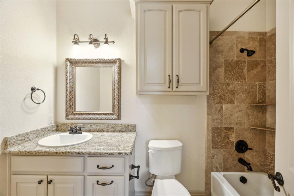 301 Harrison Circle Van Alstyne, TX 75495 - Photo 28 of 38 a bathroom with a granite countertop sink toilet and shower