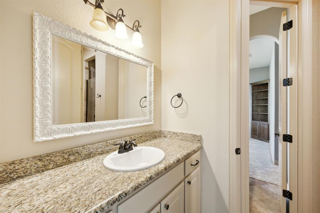 301 Harrison Circle Van Alstyne, TX 75495 - Photo 31 of 38 a bathroom with a granite countertop sink and a mirror