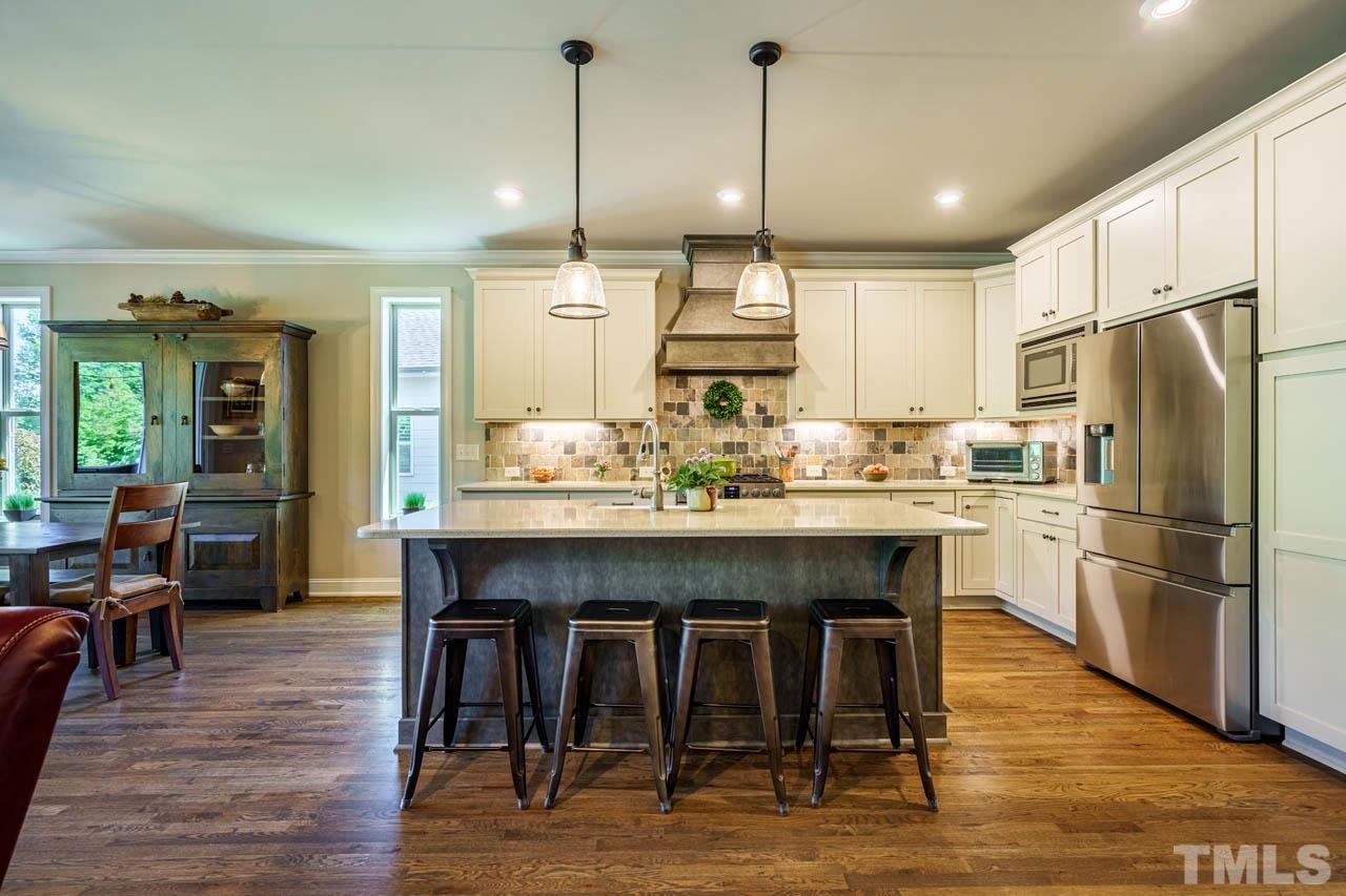394 Cliffdale Road Chapel Hill, NC 27516 - Photo 12 of 66 a kitchen with stainless steel appliances granite countertop a table chairs sink refrigerator and cabinets