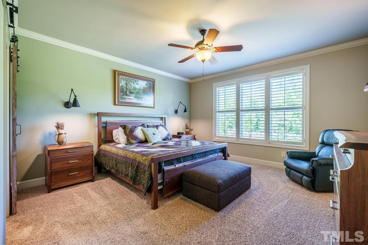 394 Cliffdale Road Chapel Hill, NC 27516 - Photo 27 of 66 a spacious bedroom with a bed and a chandelier