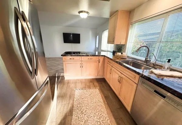 a kitchen with stainless steel appliances granite countertop a sink stove and refrigerator