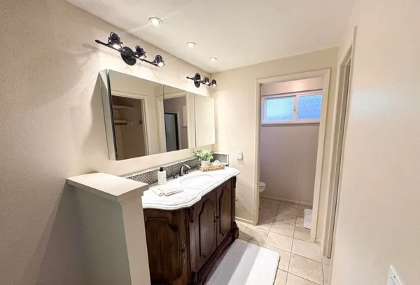 a bathroom with a sink a toilet and mirror